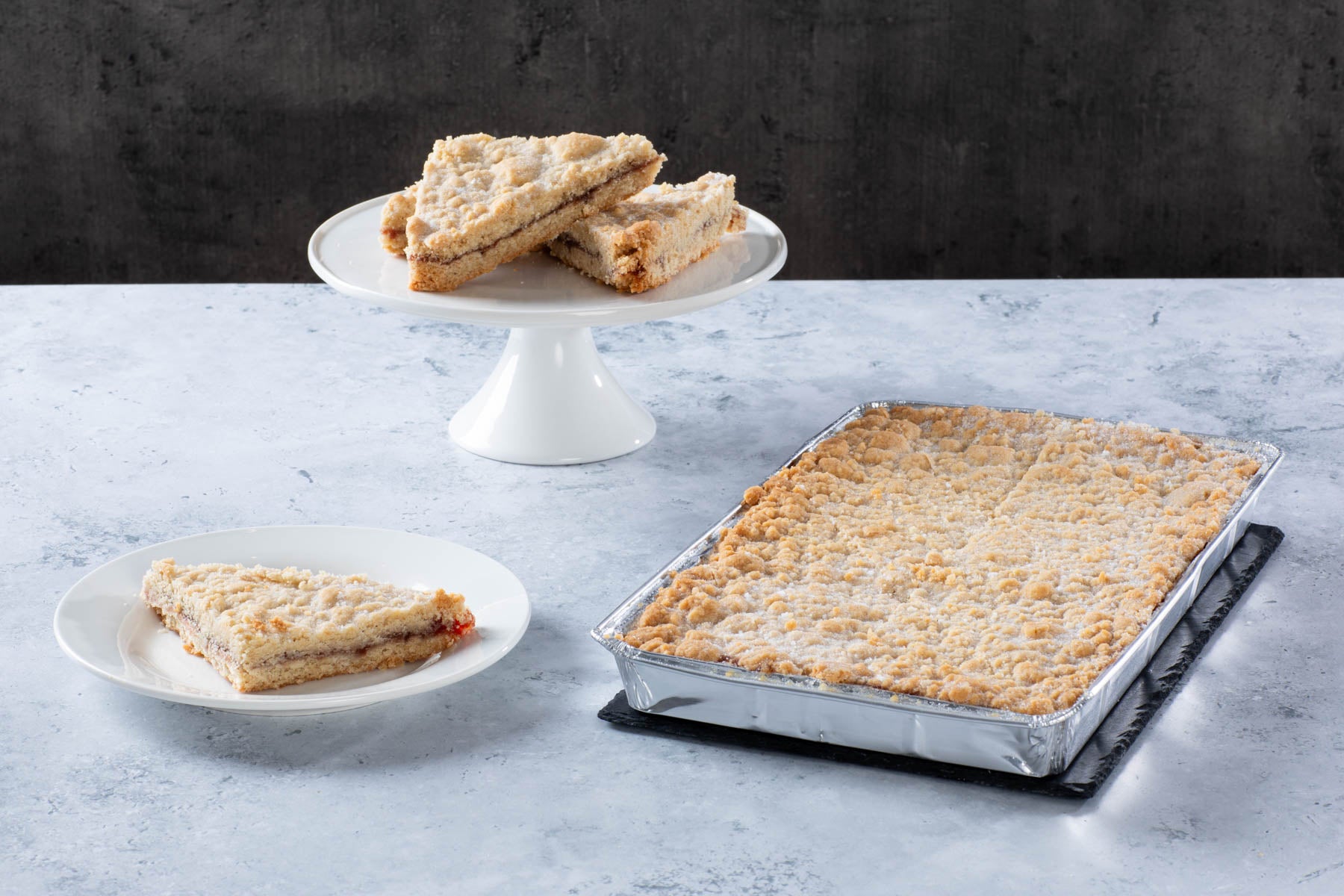 LHMC005-163_509328bf-96ba-4cae-a5e4-370b7fd61ad5.jpg a crumb-topped traybake with sliced pieces on plates
