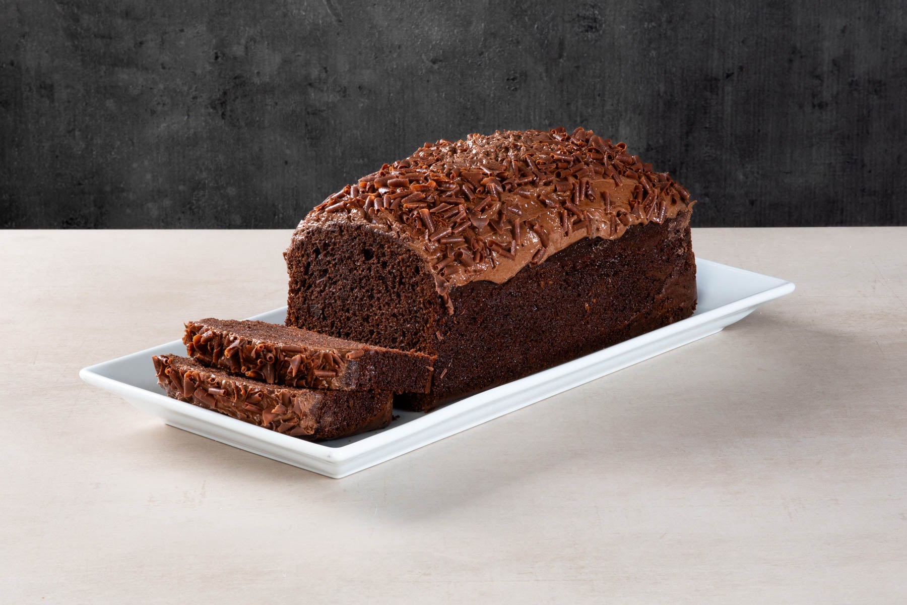 LHMC008-470.jpg Chocolate loaf cake with chocolate icing and sliced pieces.